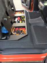 Load image into Gallery viewer, Interior of Toyota Tundra CrewMax showing the under-seat storage with tools arranged inside