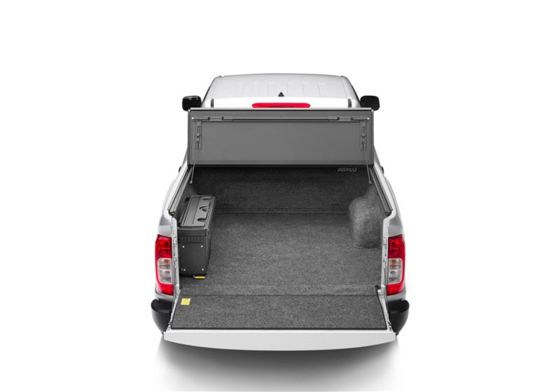 Rear view of a white Nissan Frontier with a BedRug bedliner installed