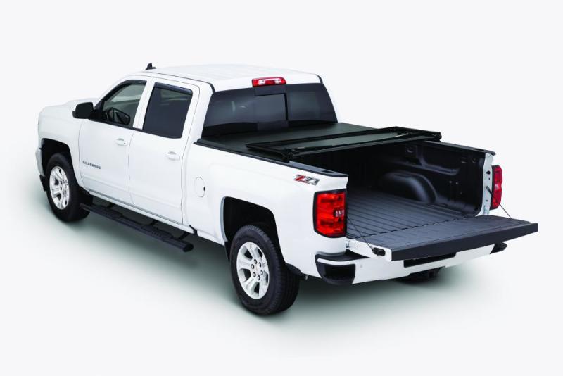 Side view of a white Chevy pickup with the Tonno Pro tonneau cover on the truck bed