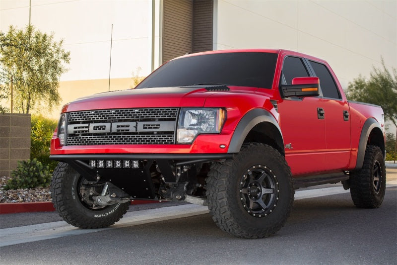 Lifted red Ford F-150 Raptor with Addictive Desert Designs front bumper