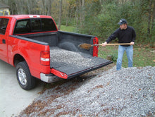 Load image into Gallery viewer, Person loading gravel into a Nissan truck bed with a BedRug liner